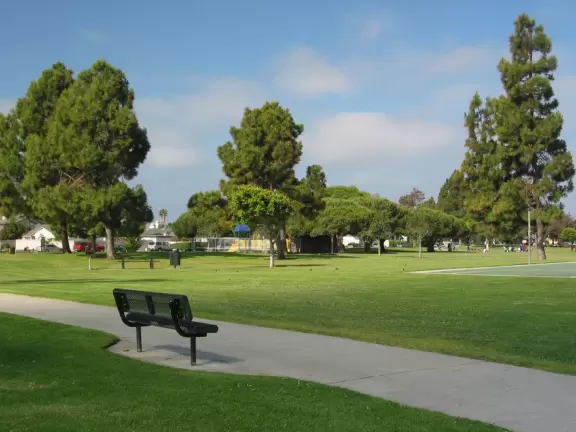 Bench, walkway, large lawn, and shade trees.
