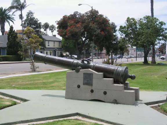 Old Spanish cannon and historical houses behind. 