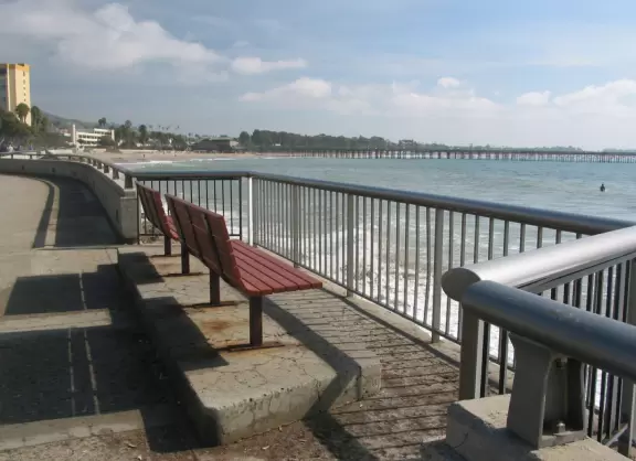 A place to sit along the promenade and watch the surfers catch waves. See the pier in the distance.