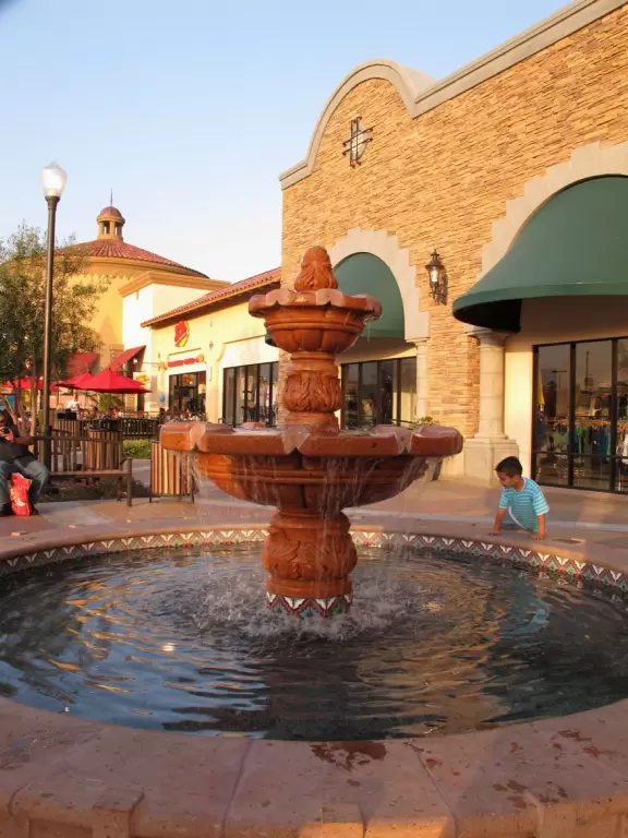 A boy plays by the fountain.