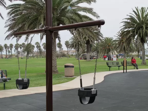 Baby swings and benches for parents.