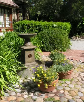 Potted flowers on a circle of rocks, at Old Monterey Inn.