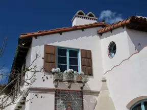 Spanish architecture at Adamson House- round deeply-set window, ironwork flowerbox, wooden shutters.