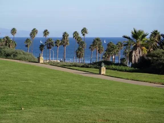 A huge green lawn looking out over the bright blue ocean and Leadbetter Beach.