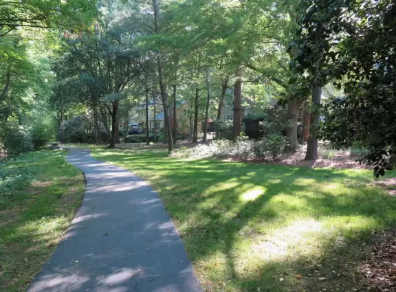 Shady greenway in forest between houses in suburban Apex.