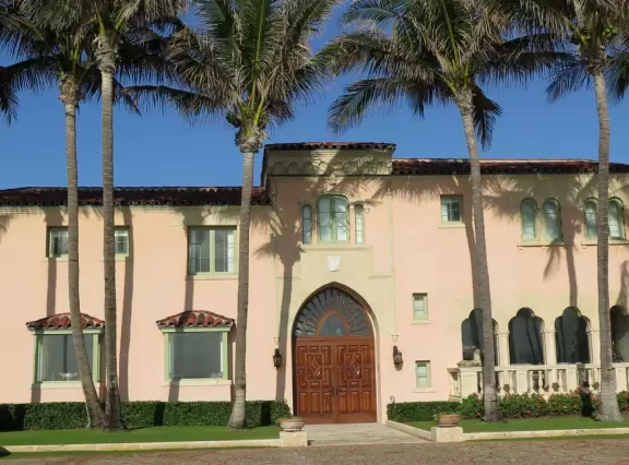 Walk past mansions in the shade of pine and palm trees on Palm Beach Island.