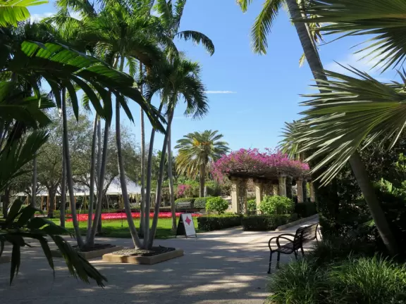 A tropical wonderland of palms, ferns, bromeliads, fountains, sculptures, rocks, ironwork gates, and pergolas, with the delightful scent of flowers filling the air.