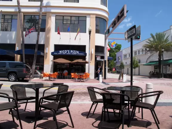 Sunny street corner with sidewalk cafes.