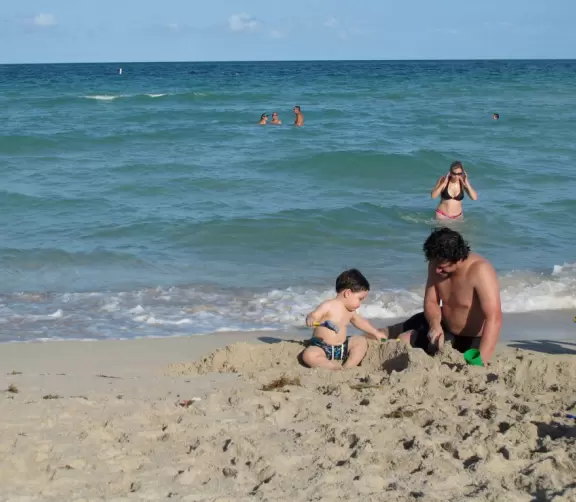 Father and son build a sandcastle.