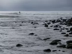 Rocky shore and surfer.