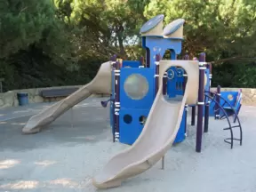 Playground that is shaped like a ship, near the soccer fields.