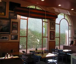 The large windows looking out on ivy at PizzaRev.