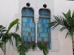 Stained glass windows and palms, at the Everglades Club, a secret social club that doesn't allow cell phones and has no sign or website.