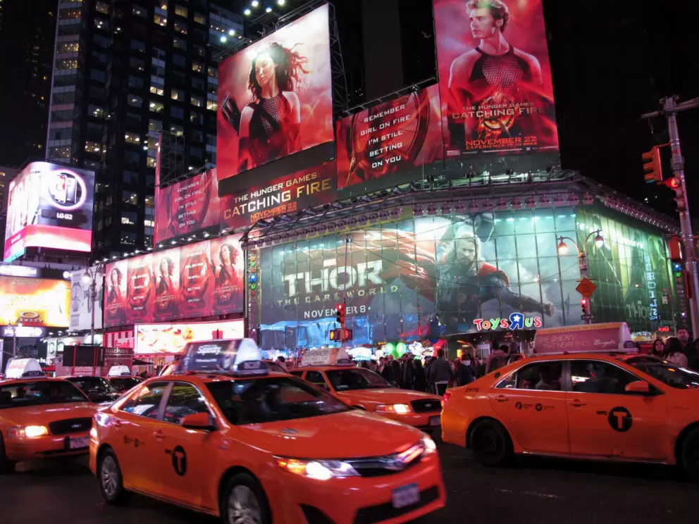 Taxis crowd the streets near the giant animated billboards.