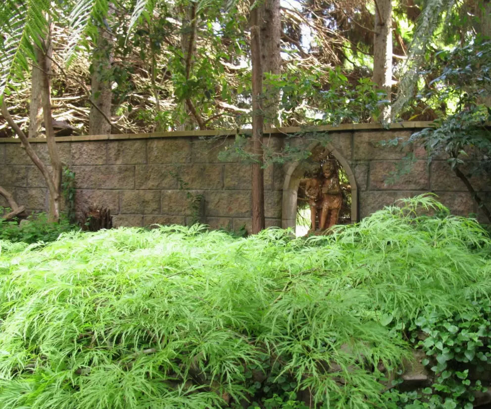 Little sculptures hidden in a pointed archway in the garden.
