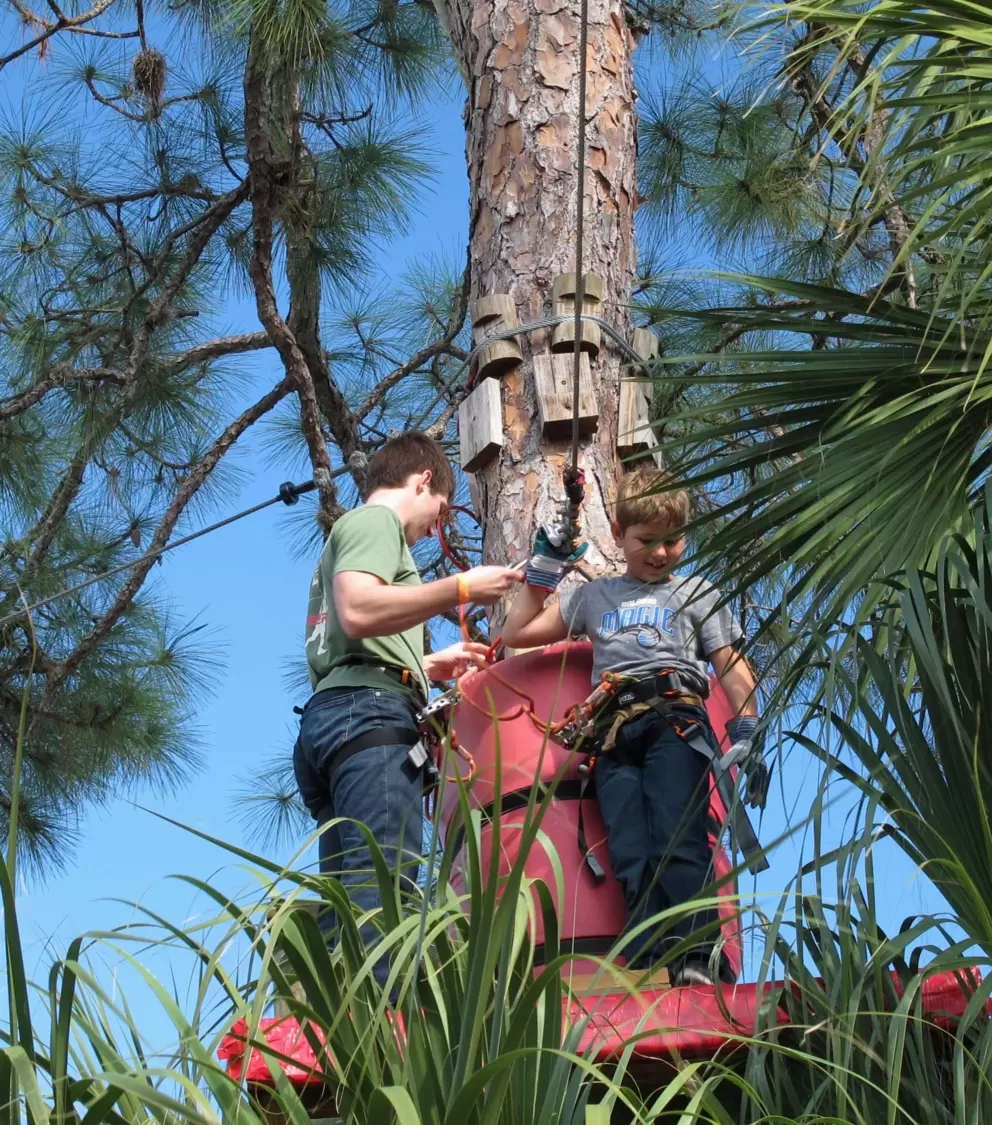 A son and his dad take a pause between ziplines.