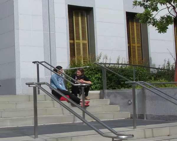 Students sitting on the steps of Stanley Hall, a recent building on campus.