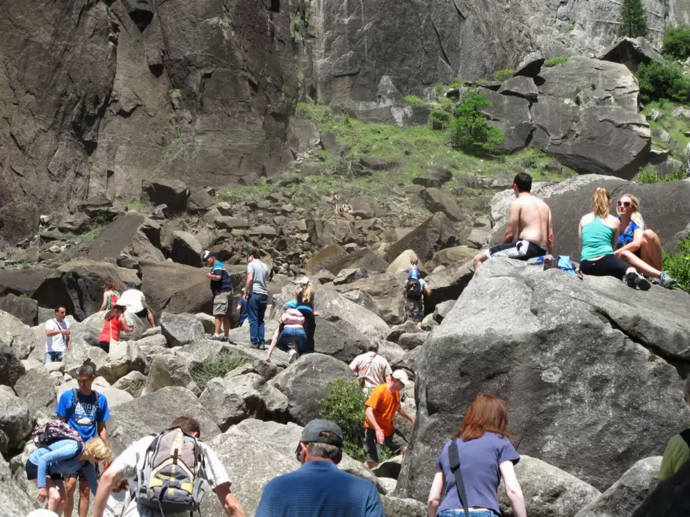 Happy visitors sitting on the boulders feeling the mist of the falls.