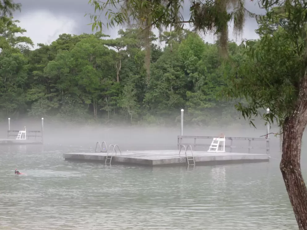 Deck on the water surrounded by fog.