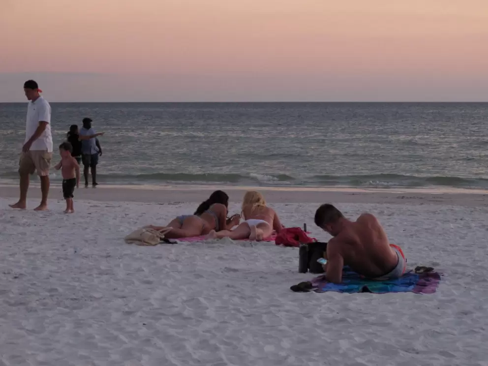 Sunbathers laying out on the sand.