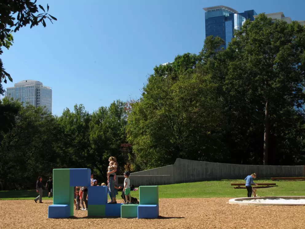 Giant blocks to climb at the Noguchi playground, with skyscrapers behind.