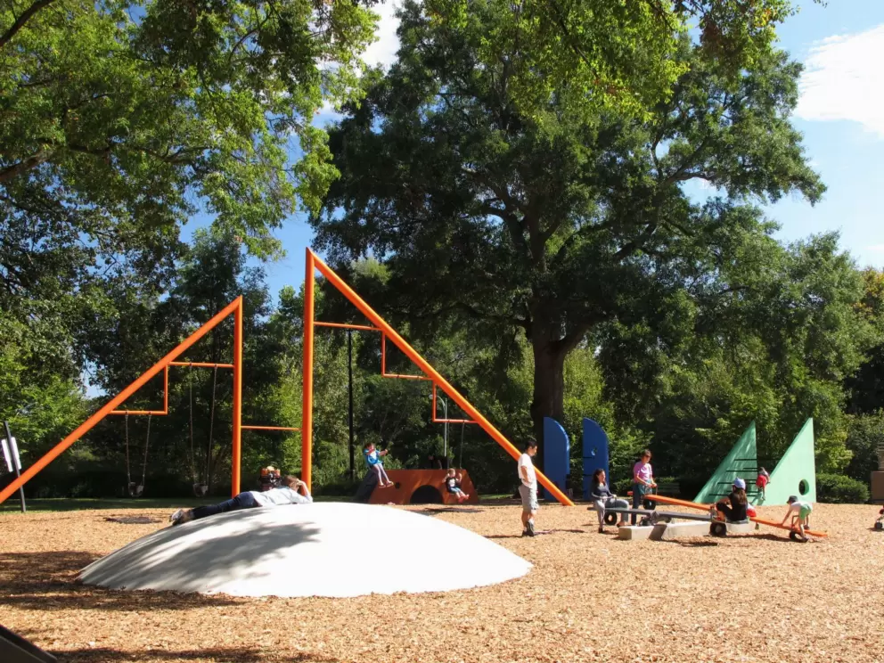Swings under a triangle, and cement hemisphere.