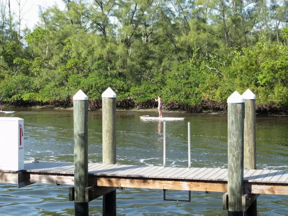 The dock near the stage, with a girl paddleboarding by.