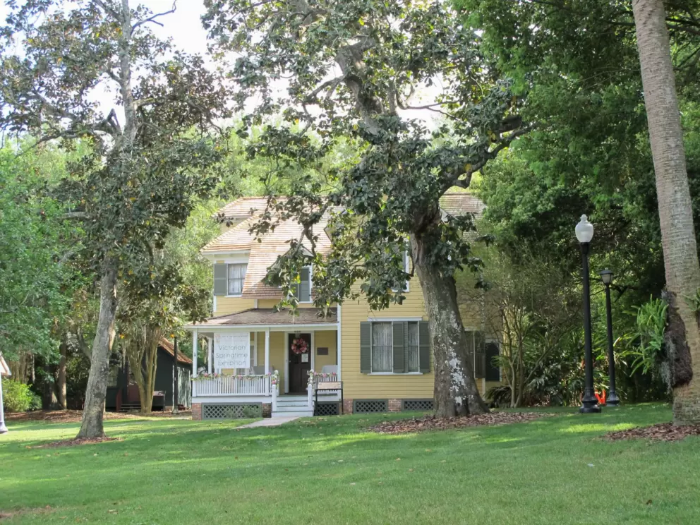 The yellow Waterhouse Residence, on a lawn that slopes up from the shore.