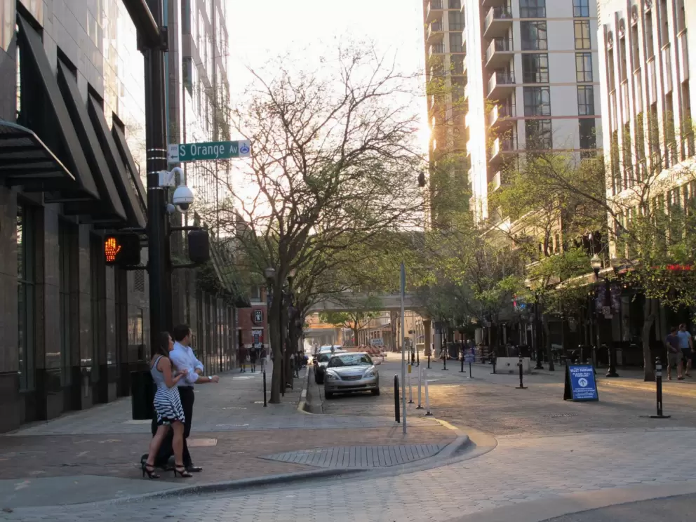 A man and woman cross the road at Orange Ave and Church St.