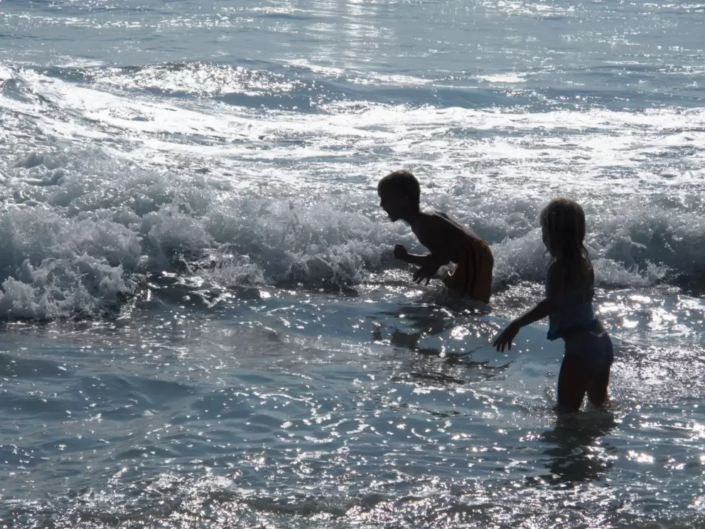 Kids playing in the waves at high tide.