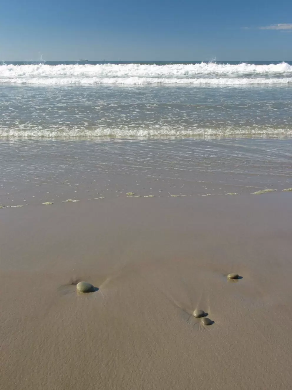 I loved how the little pebbles looked, scattered about on the shore, and the tiny, clear waves that rolled up to them.