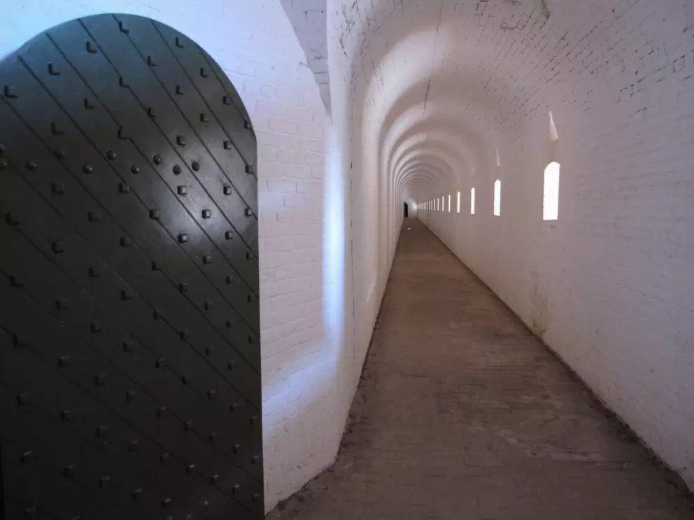 Beautiful iron door and long white arched tunnel.