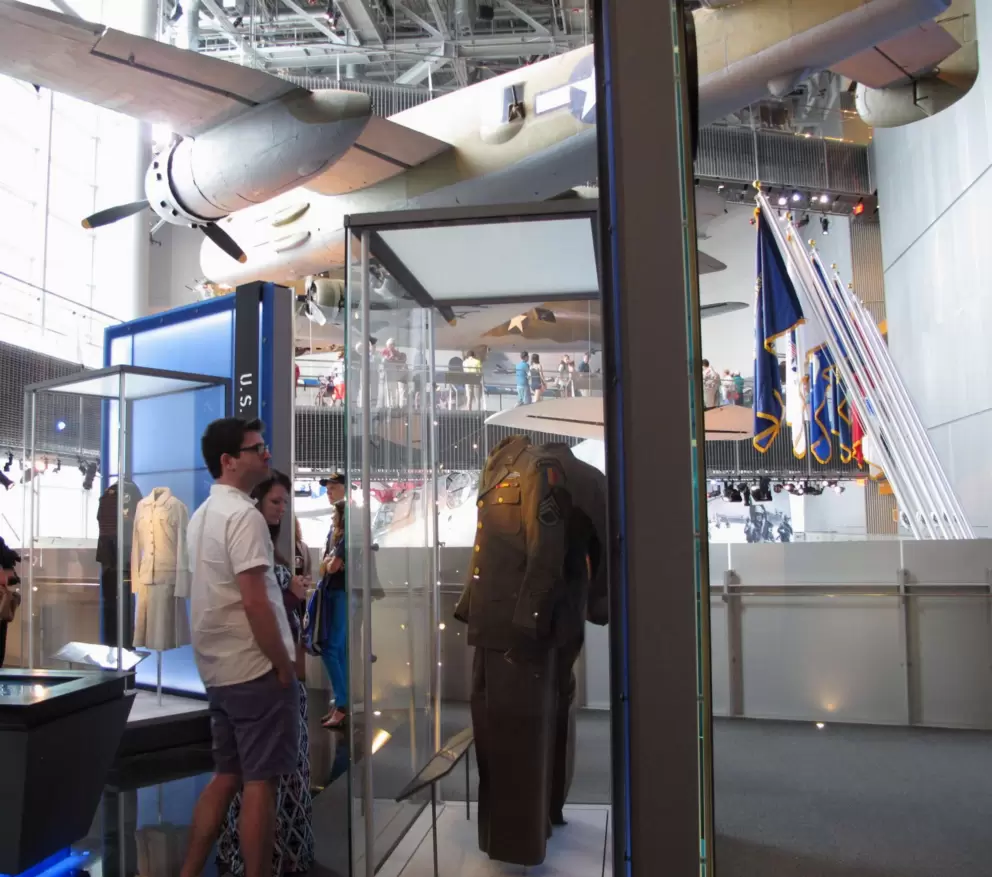 A young couple checks out an exhibit of uniforms. 