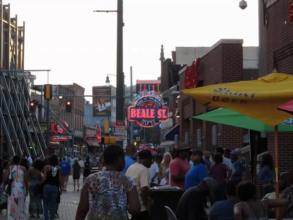 Crowds fill the street in the early evening.