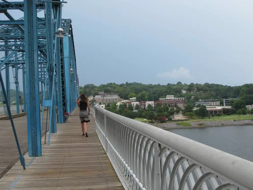 A lady walks across the Walnut Street Bridge.