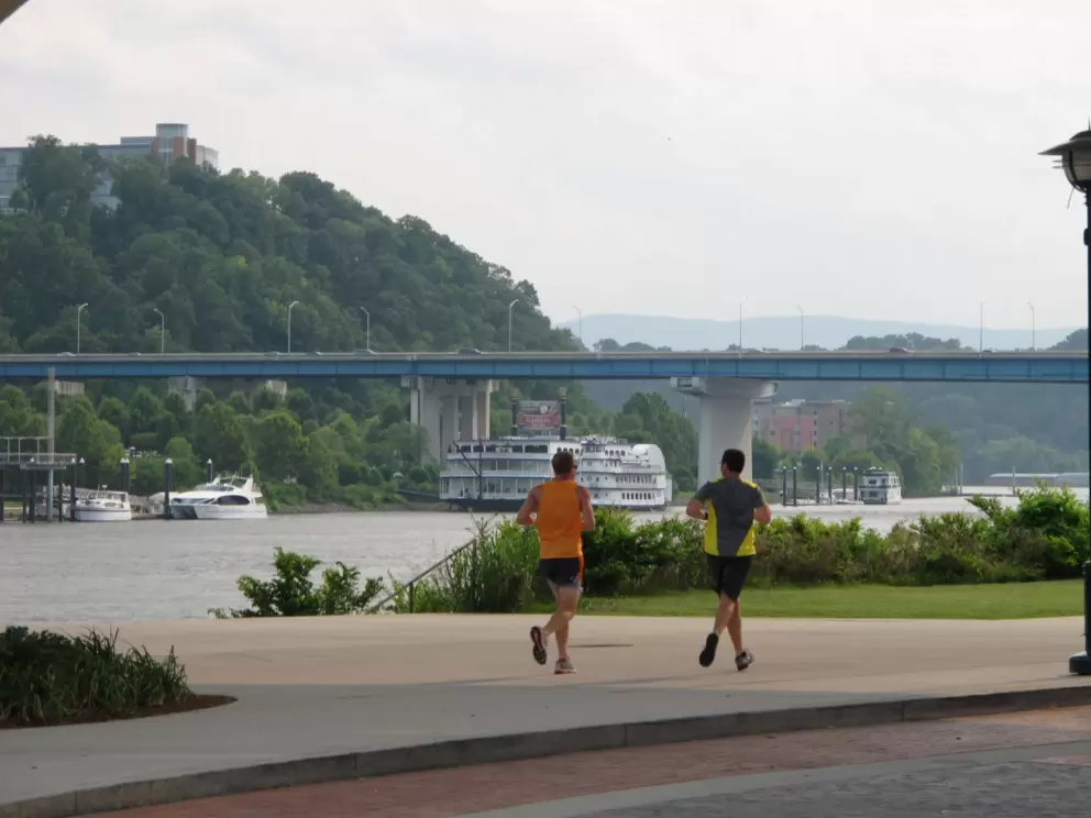 Joggers enjoy a run beside the river.