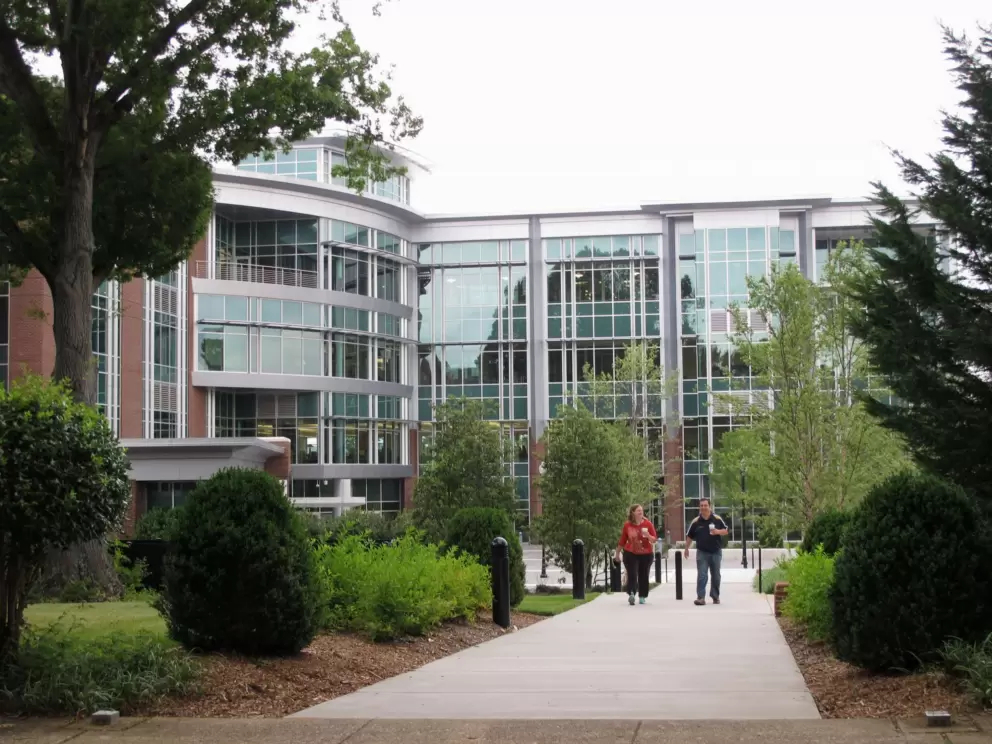 Administrators walk in front of a modern building.