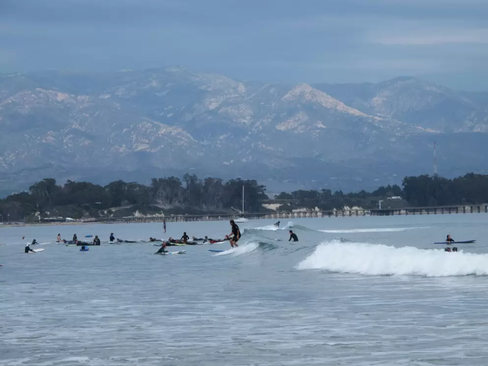 Surfers and mountains behind.