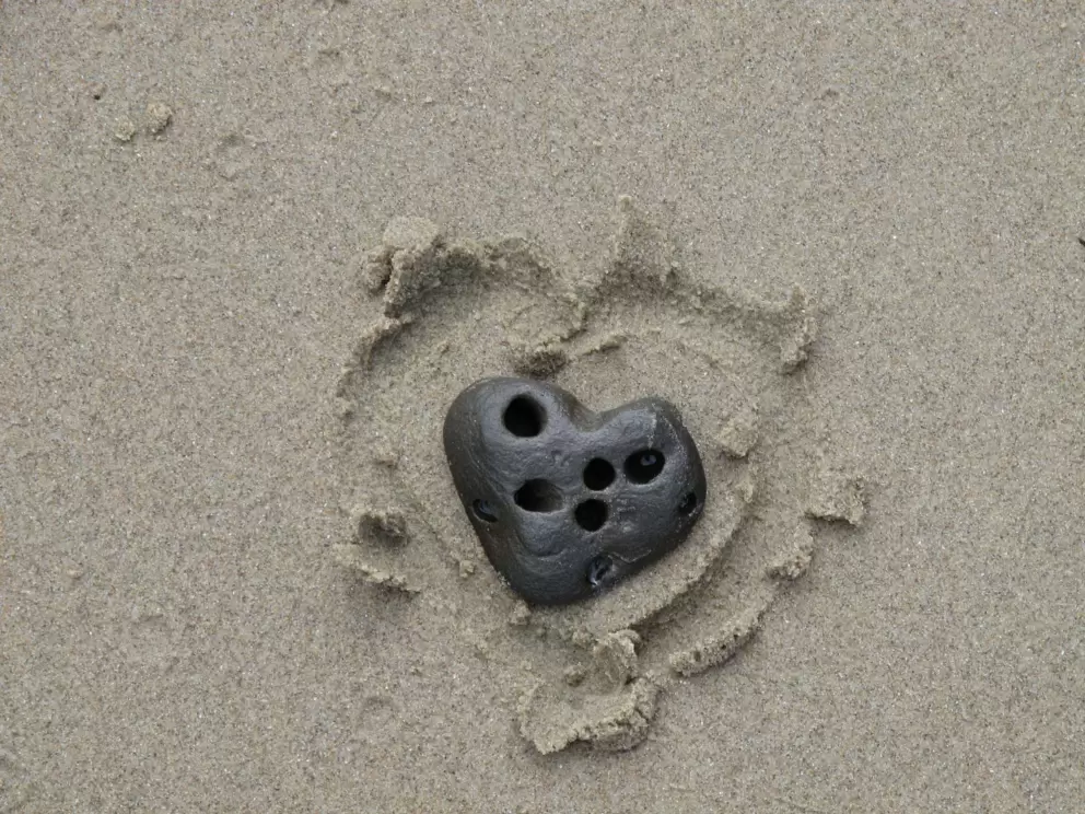 Heart-shaped rock in the sand.