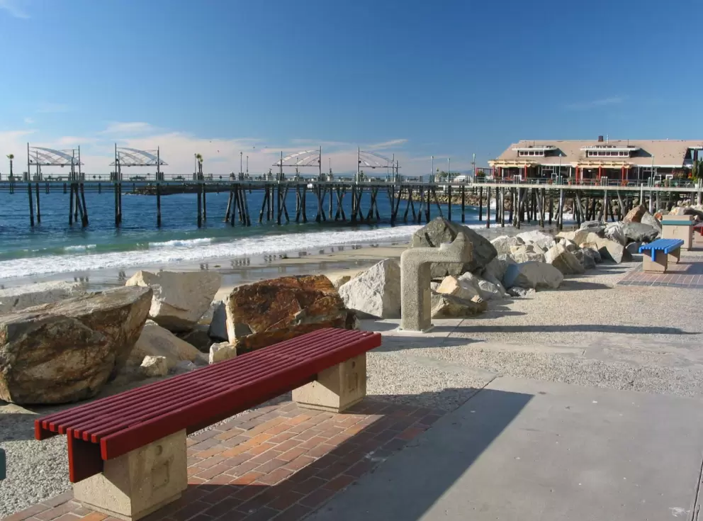 Colorful benches at the boardwalk which leads, on your circular walk, back to Kincaid's where the walk begins. See the lovely patch of sand below, and the pier in the distance.