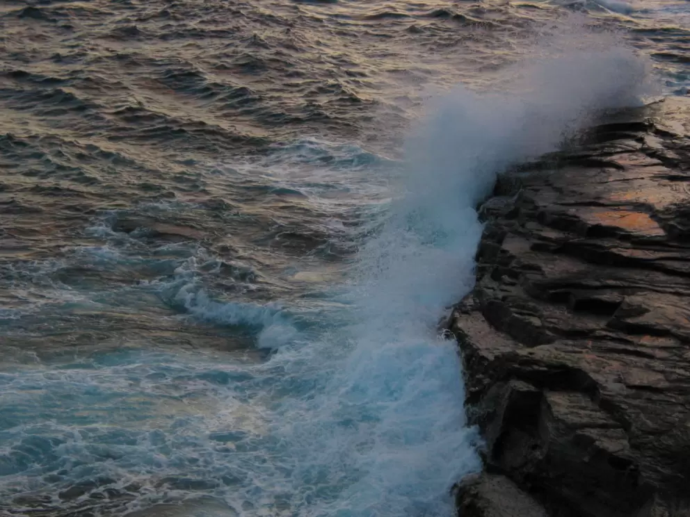 Waves crashing over rocks below.