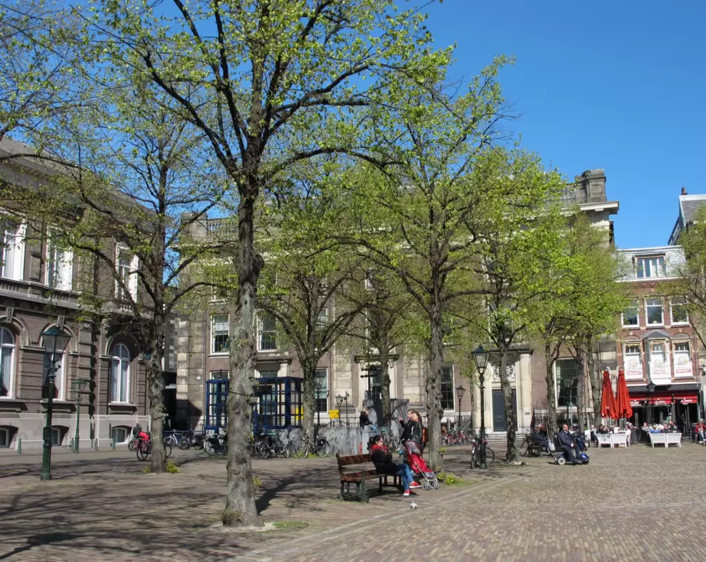People hang out on the benches on the periphery of the square.