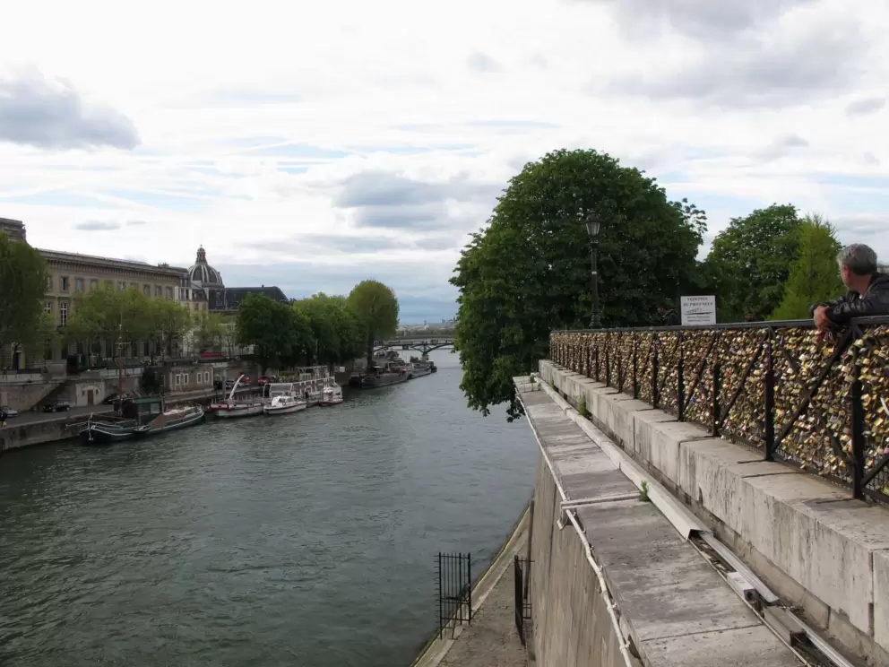A man who sells locks looks out over the river.