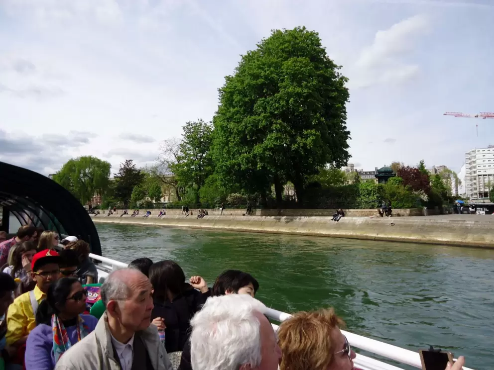 Boat passengers check out all the people relaxing on the banks of the Seine.