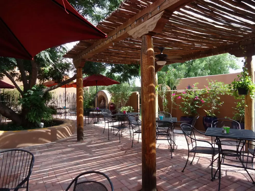 Sculpture, plants, and adobe walls in the back patio of Josefina's.