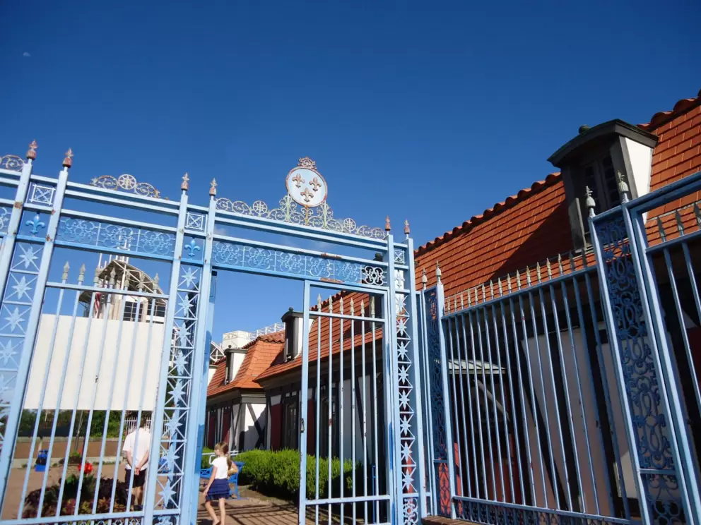 Pale blue ironwork entrance gate. 