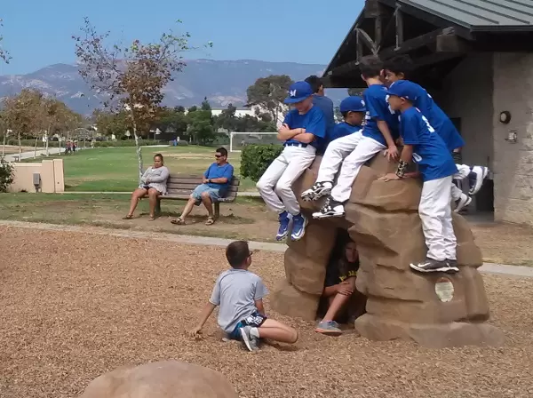 Baseball boys enjoying the rock arch on the playground.