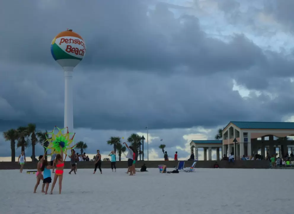 Flying a kite, with the giant beach ball in the distance.