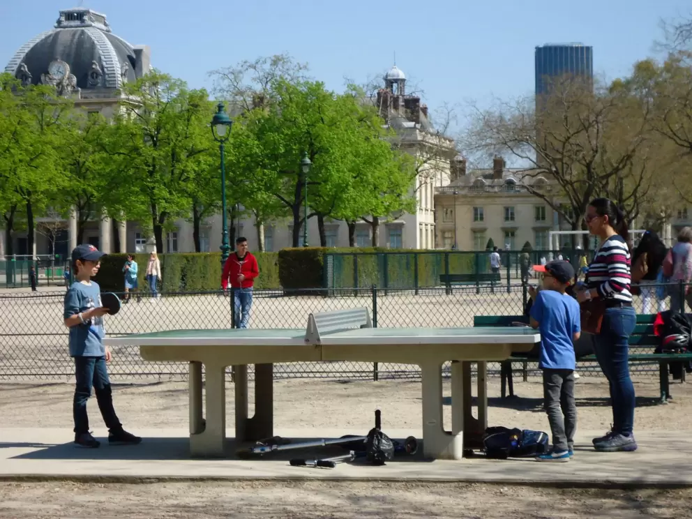 A family plays ping pong at the park.