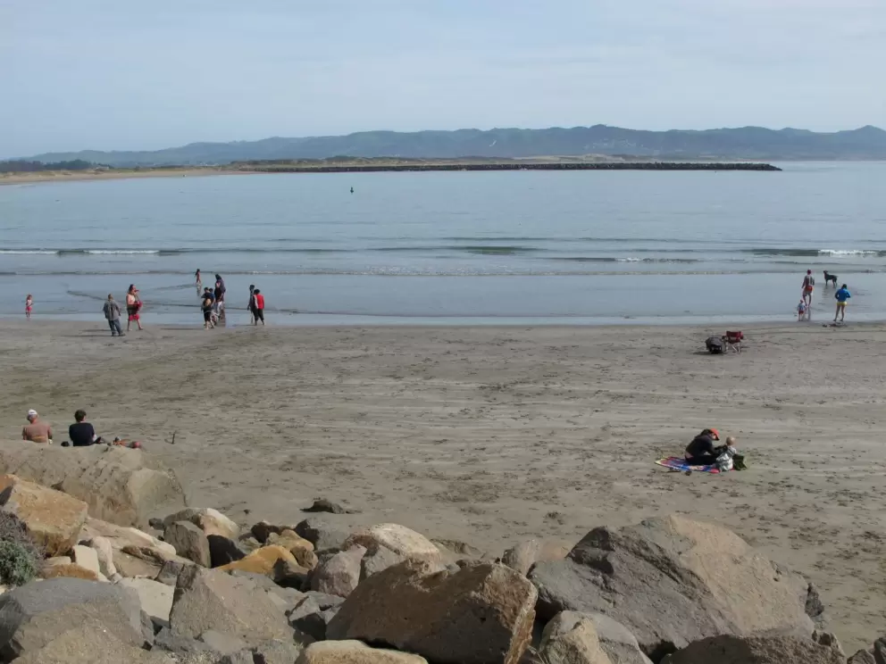 Families enjoy the beach at the far end of the Harborwalk.